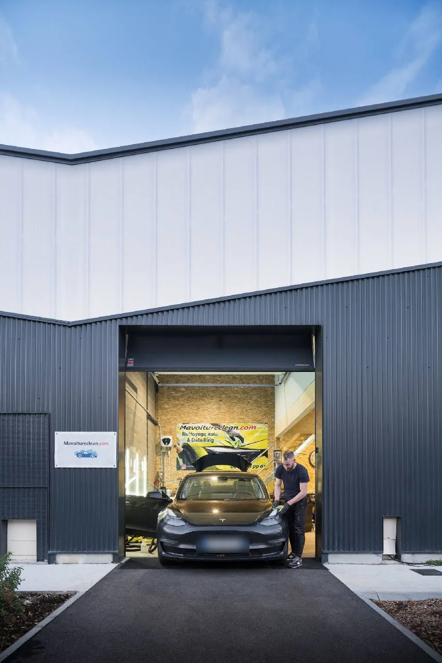 Façade de l'atelier Mavoitureclean à Mérignac, une Tesla en cours de nettoyage à l'entrée