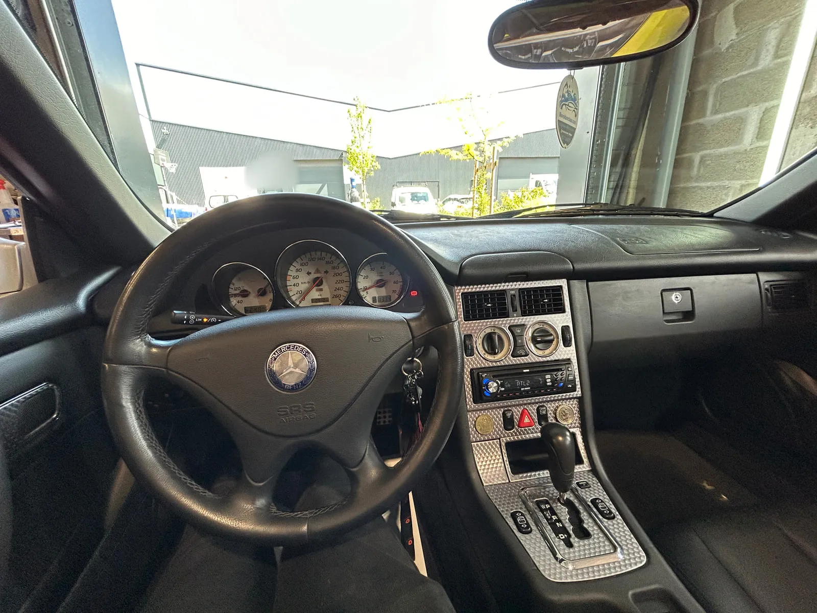 Poste de conduite d'une Mercedes SLK : volant à l'étoile, compteurs à fond clair, console argent