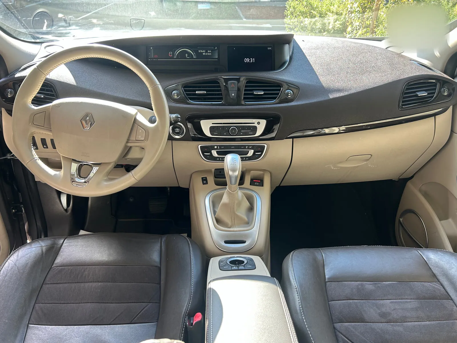 Habitacle d'une Renault vu de face : volant crème, planche de bord bicolore, sièges sombres